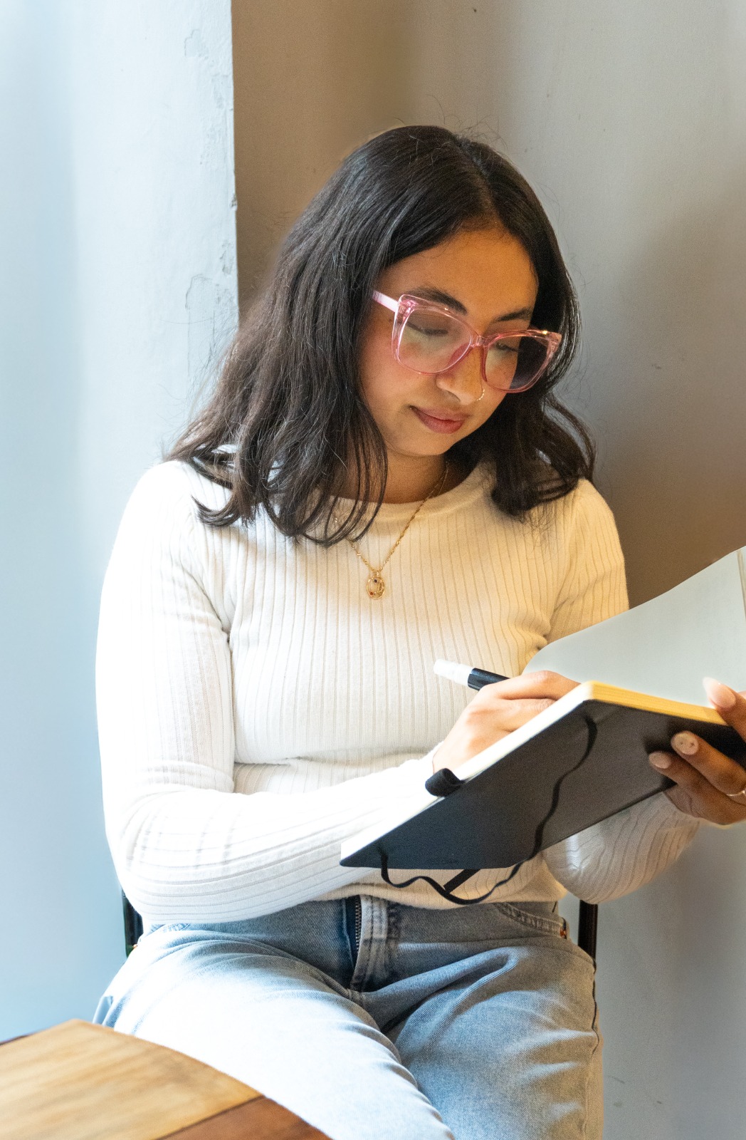 Tania Máximo escribiendo en una libreta